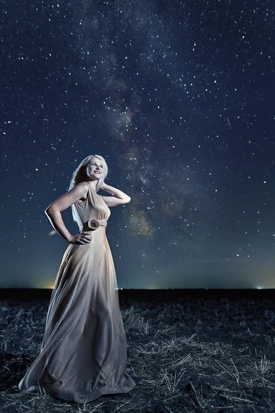 天の川夜空の下で長いドレスでエレガントな美しい女性 — ストック写真