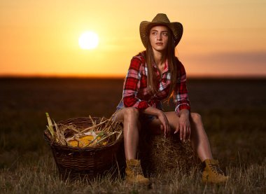 Mısır hasadında şapkalı ve ekose gömlekli güzel çiftçi kadın.