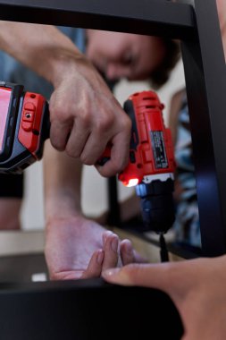 Yeni evlerinde mobilya montajı yapan genç bir çift.