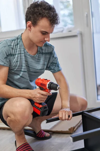 Jongeman Monteert Meubels Zijn Nieuwe Huis Nieuw Levensconcept — Stockfoto