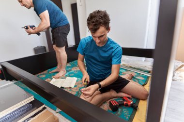 Baba oğluna yeni evinde mobilya montajında ve yapımında yardım ediyor.