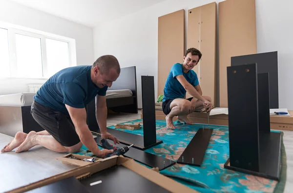 Pai Ajudando Seu Filho Montagem Construir Móveis Sua Nova Casa — Fotografia de Stock