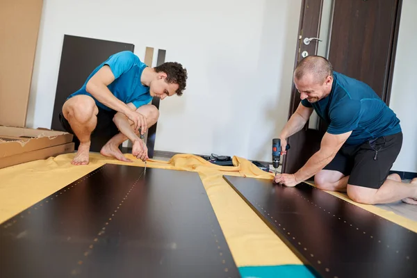 Pai Ajudando Seu Filho Montagem Construir Móveis Sua Nova Casa — Fotografia de Stock