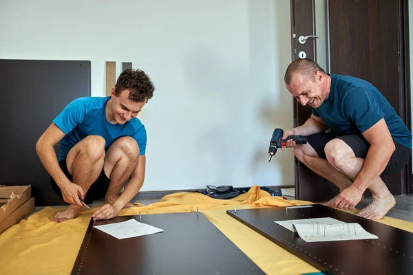 Pai Ajudando Seu Filho Montagem Construir Móveis Sua Nova Casa — Fotografia de Stock