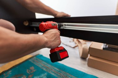 Adam taşınırken yeni mobilyalarını monte ediyor.