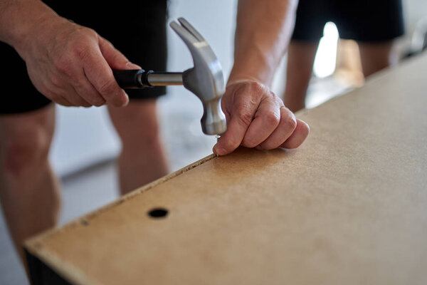 Человек собирает свою новую мебель при переезде