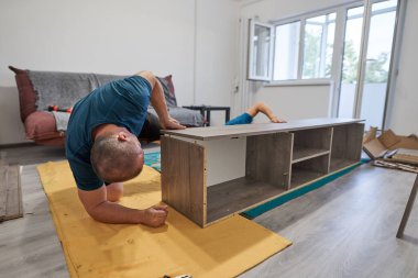 Baba oğluna yeni evinde mobilya montajında ve yapımında yardım ediyor.