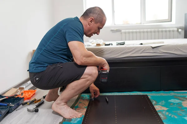 Man Assembling His New Furniture Moving House — Stock Photo, Image