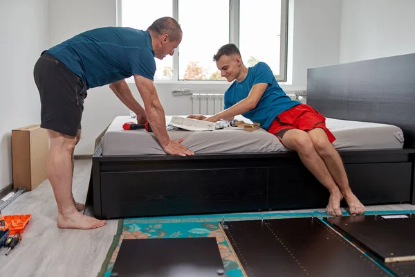 Pai Ajudando Seu Filho Montagem Construir Móveis Sua Nova Casa — Fotografia de Stock