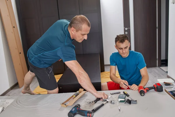 Pai Ajudando Seu Filho Montagem Construir Móveis Sua Nova Casa — Fotografia de Stock