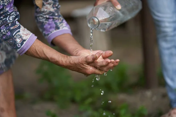 Old Woman Farmer Washing Her Hands Outdoor Water Plastic Bottle — Stock Photo, Image