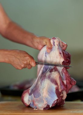 Kadının elleri et kesiyor, evde et hazırlıyor.