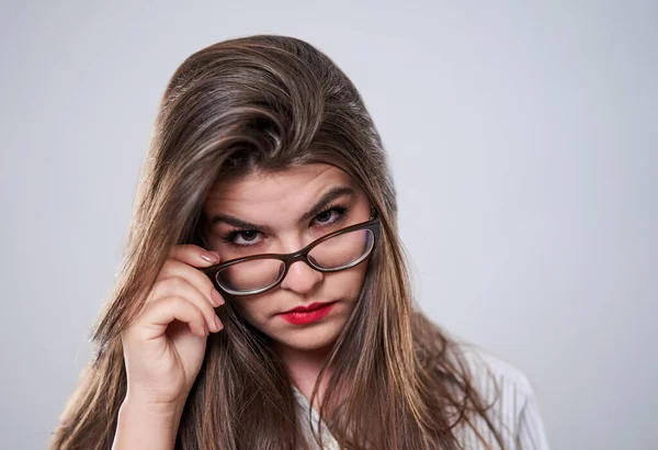 Gri Arka Planda Gözlüklü Şüpheli Genç Bir Kadınının Yakın Çekimi — Stok fotoğraf