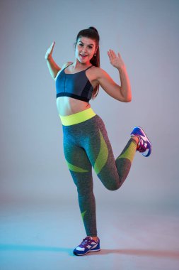 Ayrıca spor yapan kendine güvenen güzel bir kadın. Mavi-kırmızı tonlama. Stüdyo çekimi.