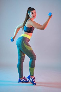 Ayrıca spor yapan kendine güvenen güzel bir kadın. Mavi-kırmızı tonlama. Stüdyo çekimi.