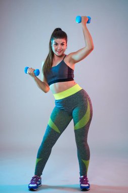 Ayrıca spor yapan kendine güvenen güzel bir kadın. Mavi-kırmızı tonlama. Stüdyo çekimi.