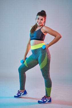 Ayrıca spor yapan kendine güvenen güzel bir kadın. Mavi-kırmızı tonlama. Stüdyo çekimi.