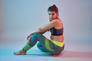 Ayrıca spor yapan kendine güvenen güzel bir kadın. Mavi-kırmızı tonlama. Stüdyo çekimi.