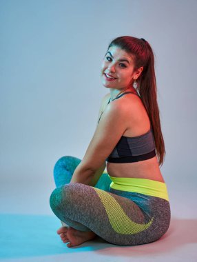 Ayrıca spor yapan kendine güvenen güzel bir kadın. Mavi-kırmızı tonlama. Stüdyo çekimi.