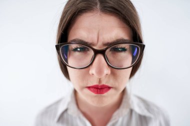 Öfkeyle kaşlarını çatan genç bir iş kadınının geniş açılı görüntüsü.