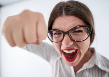 Kameraya yumruk atan genç ve son derece kızgın bir iş kadınının geniş açılı görüntüsü.