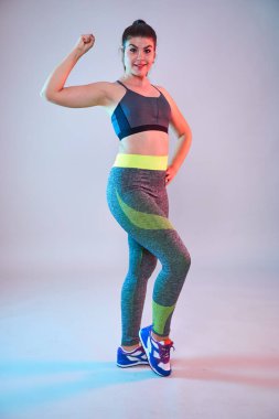 Ayrıca spor yapan kendine güvenen güzel bir kadın. Mavi-kırmızı tonlama. Stüdyo çekimi.