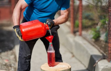 Oduncu testereyi özel bir gaz ve yağ karışımıyla dolduruyor.