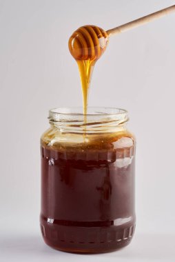 Ballı kavanoza batırmak, beyaz arka planda izole edilmiş