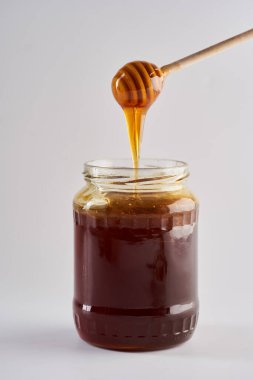 Ballı kavanoza batırmak, beyaz arka planda izole edilmiş