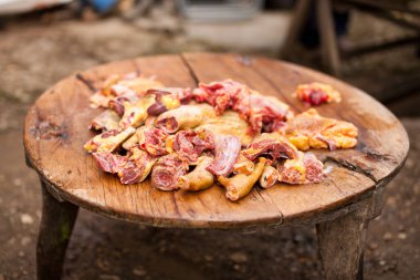 Yıpranmış, eski, yuvarlak ahşap bir masada çiğ tavuk eti.
