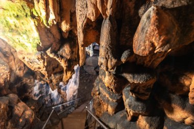 Kireçtaşı mağarasının iç kısmının oluşumlarda büyüyen sarkıtlar, sütunlar ve yosun örtüsüyle manzarası