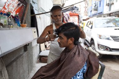 Yeni Delhi, Hindistan - 18 Temmuz 2018: Street Kuaför kesim saç yol kenarına yerleştirilen bir salon.