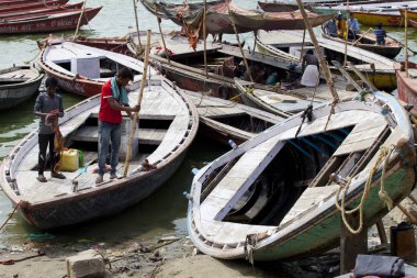 Varanasi, Uttar Pradesh, Hindistan - 10 Temmuz 2018: Kutsal ghats Varanasi yakınındaki Ganj Nehri kıyısında ahşap eski tekne palamarla