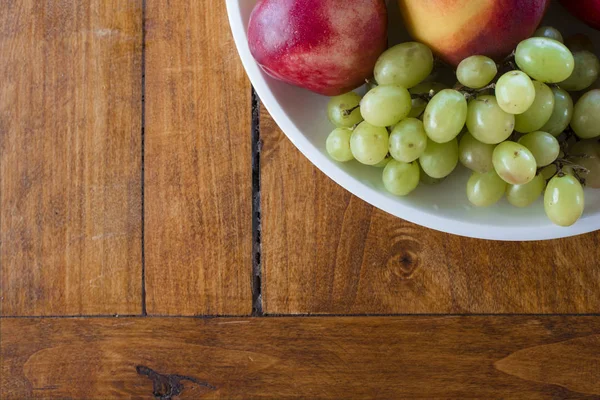 Fruitschaal Met Appel Perzik Druiven Geschoten Vanuit Bovenaanzicht Hoek Houtstructuur — Stockfoto