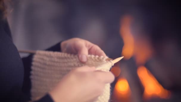 在温暖的冬天模糊背景的壁炉编织的妇女手缝合 女孩做放松针织活动与羊毛室内在家里 — 图库视频影像