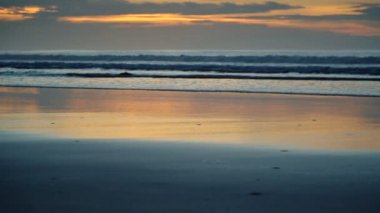 Plaj sahil peyzaj rahatlatıcı ile kıyı şeridi üzerinde günbatımı zaman çökmesini dalgalar. İçinde mavi su deniz kıyı tatil tropikal ağır çekim görüntüleri.