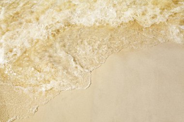 Sahilde kum, deniz kıyısında dalgalar sıçrama.