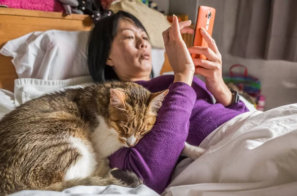 Kobieta Pomocą Telefonów Komórkowych Łóżku Kotem — Zdjęcie stockowe