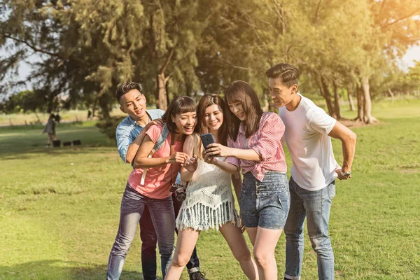 Aziatische Mensen Kijken Iets Cellphone Met Zijn Vrienden Het Park — Stockfoto
