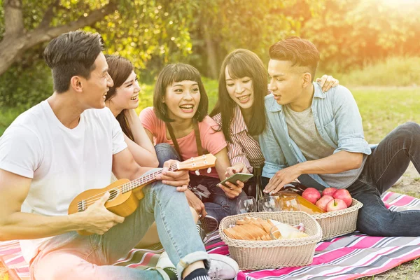 Asian people look something at cellphone with his friends in the park