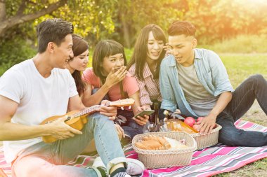 Asya insanlar bakmak bir şey cep telefonu parkta arkadaşlarıyla