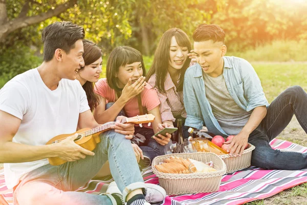 Asya insanlar bakmak bir şey cep telefonu parkta arkadaşlarıyla