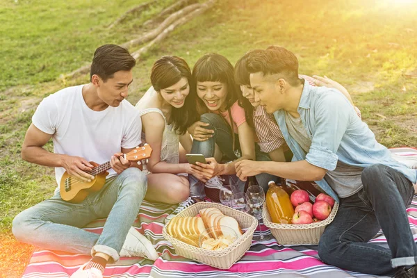 Asiatici Guardare Qualcosa Cellulare Con Suoi Amici Nel Parco — Foto Stock