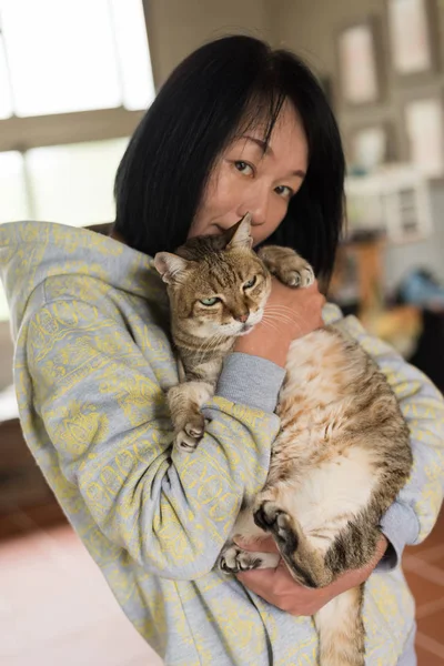 女人抱着她的老猫在家里 — 图库照片