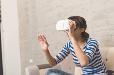 Asyalı kadın evde VR kulaklık kullanma