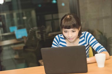 Asyalı kadın geceleri, evde çalışma konsept dizüstü bilgisayar kullanarak