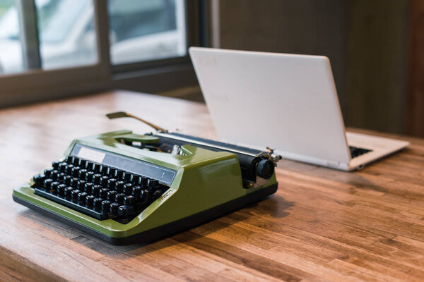 old typewriter and laptop on the table