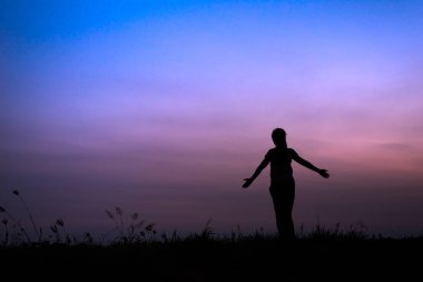 yoga ile genç kadın silüeti açık içinde poz