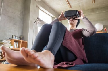 Olgun kadın evde VR kulaklık kullanarak