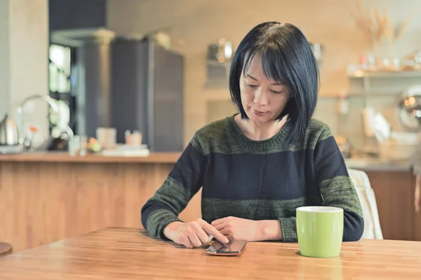 亚洲成熟妇女在家使用智能手机 — 图库照片
